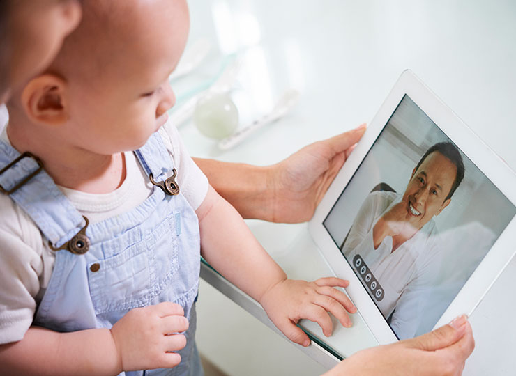 Photo of parent consults with doctor via telemedicine